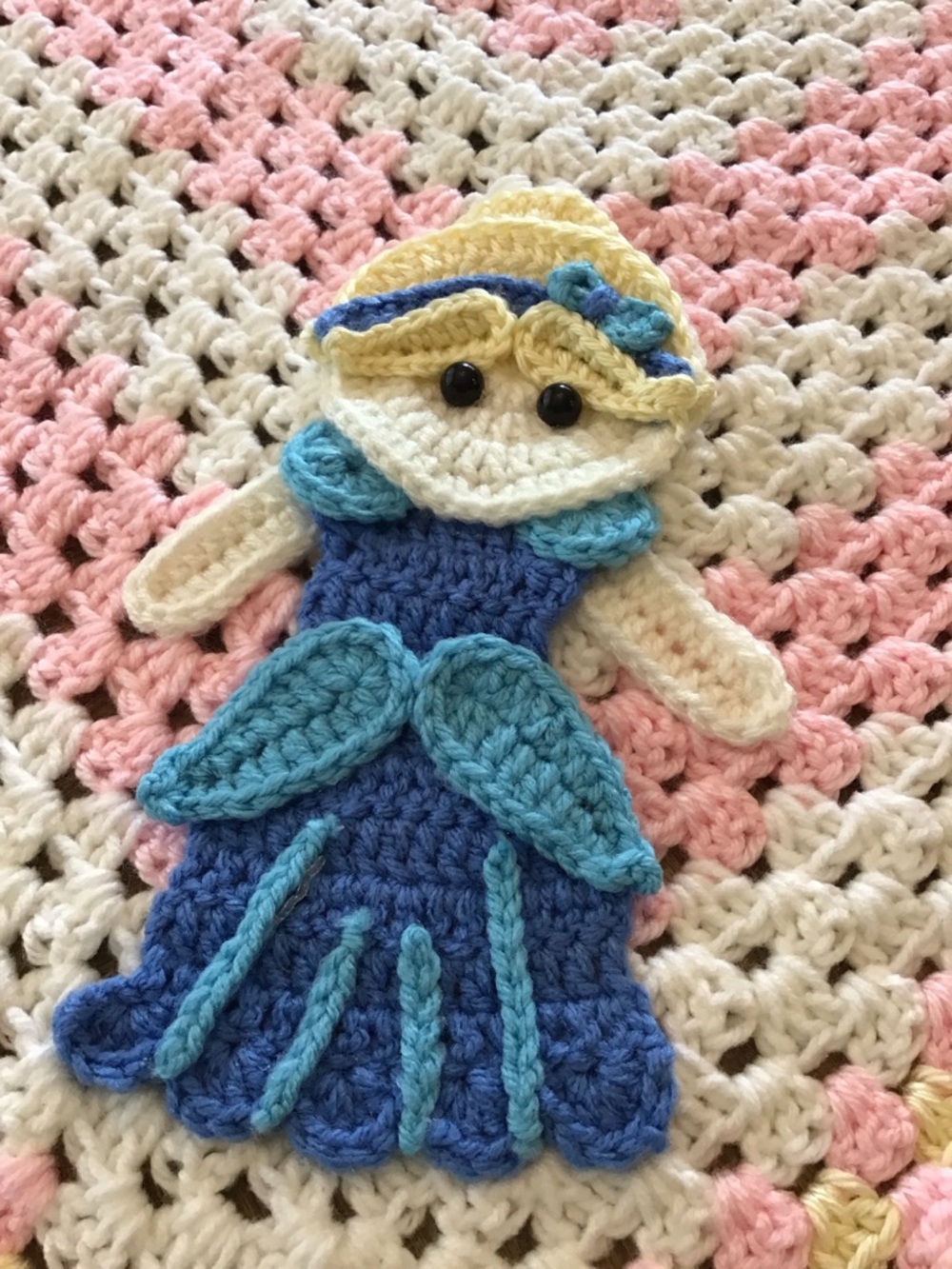 Handmade crocheted baby blanket featuring a decorative princess.